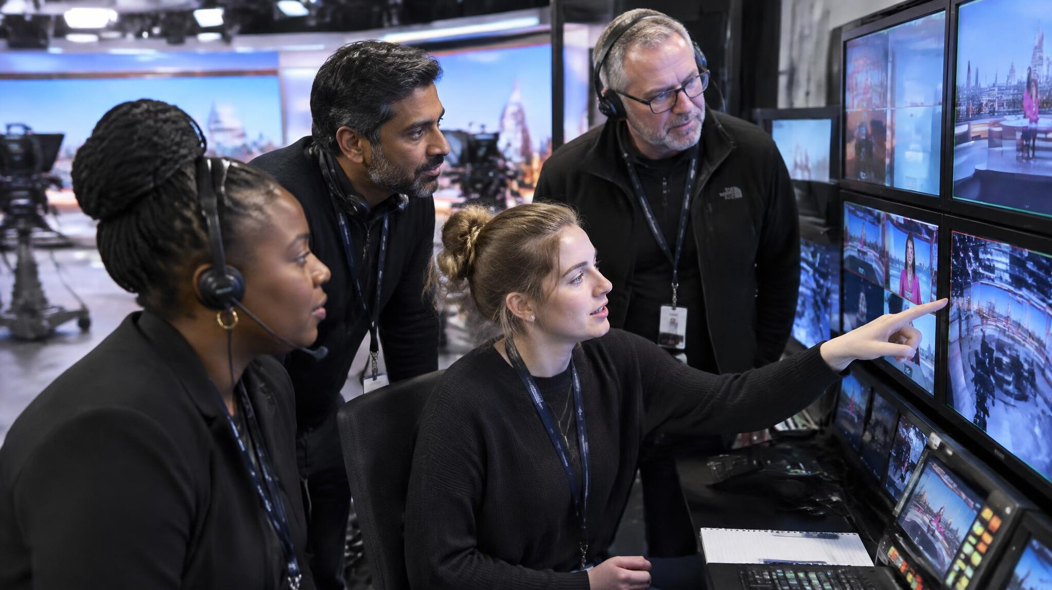 Team of broadcast engineers reviewing live feed footage together